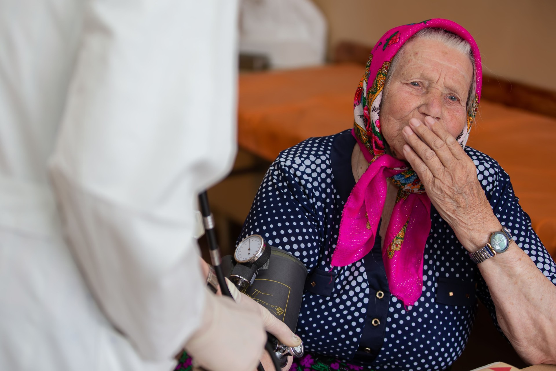 The doctor measures the pressure of an elderly woman.